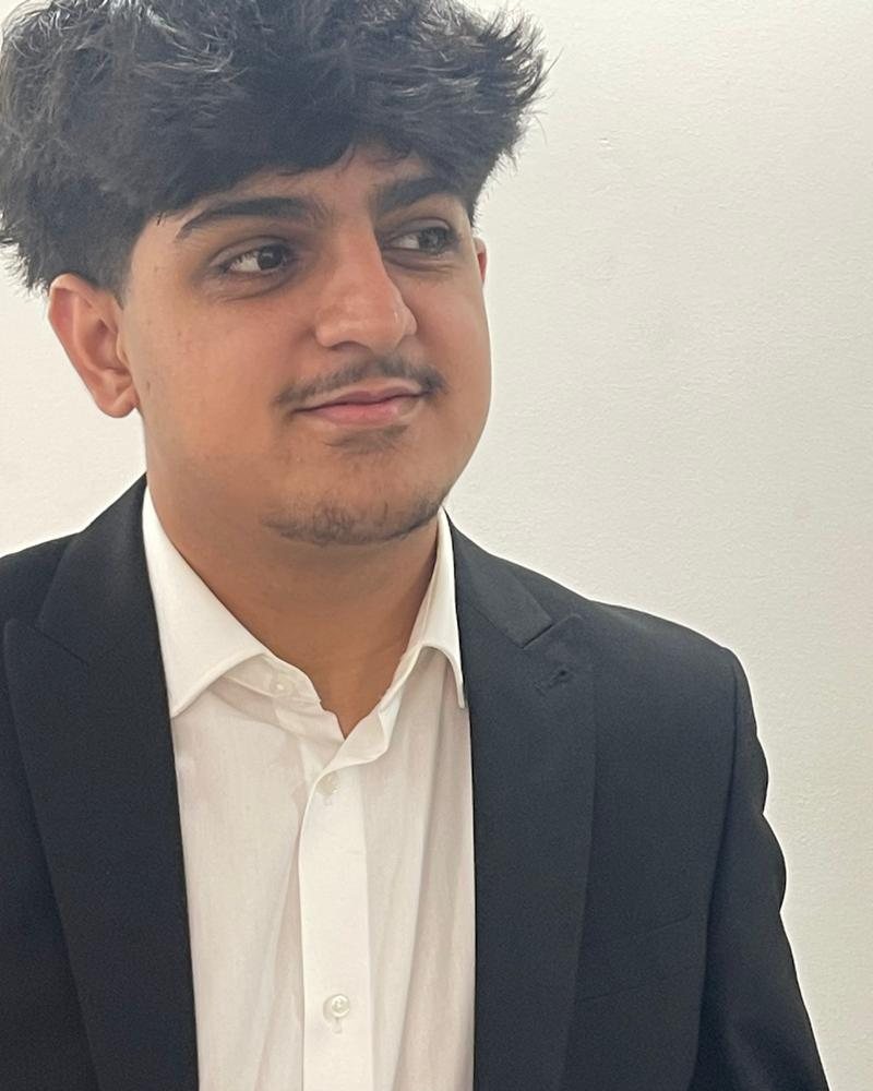 Abdullah Akbar in a dark suit and white shirt